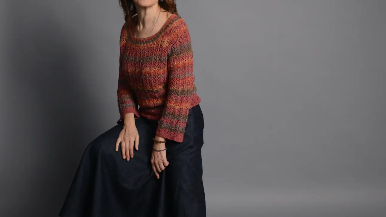 The image shows a heathered red-orange knitted sweater in size M.