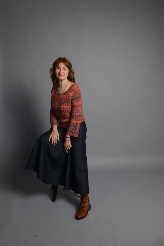 The image shows a heathered red-orange knitted sweater in size M.