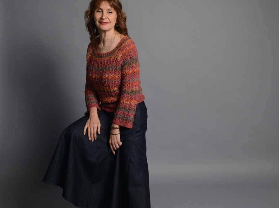 The image shows a heathered red-orange knitted sweater in size M.