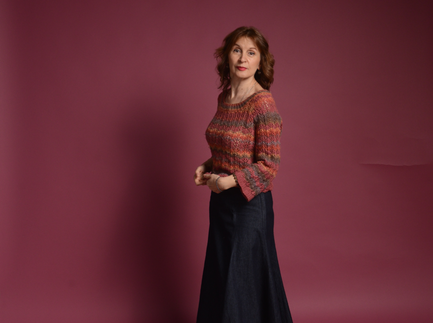 The image shows a heathered red orange knitted sweater in size M